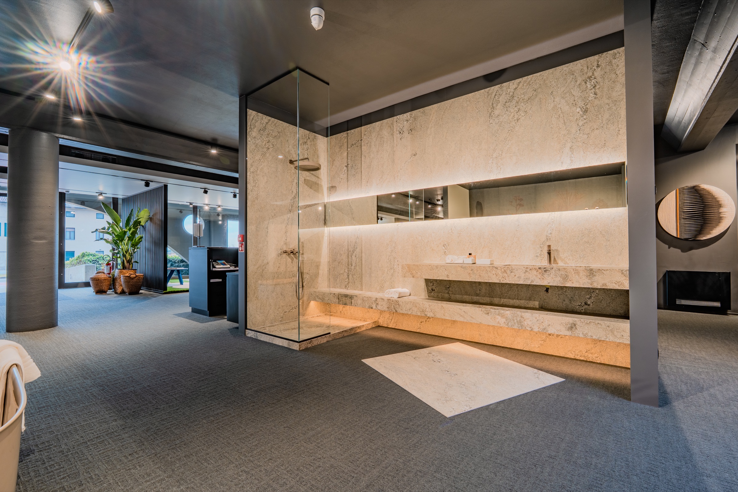 Bagno espositivo in quarzite e travertino con doccia in pietra